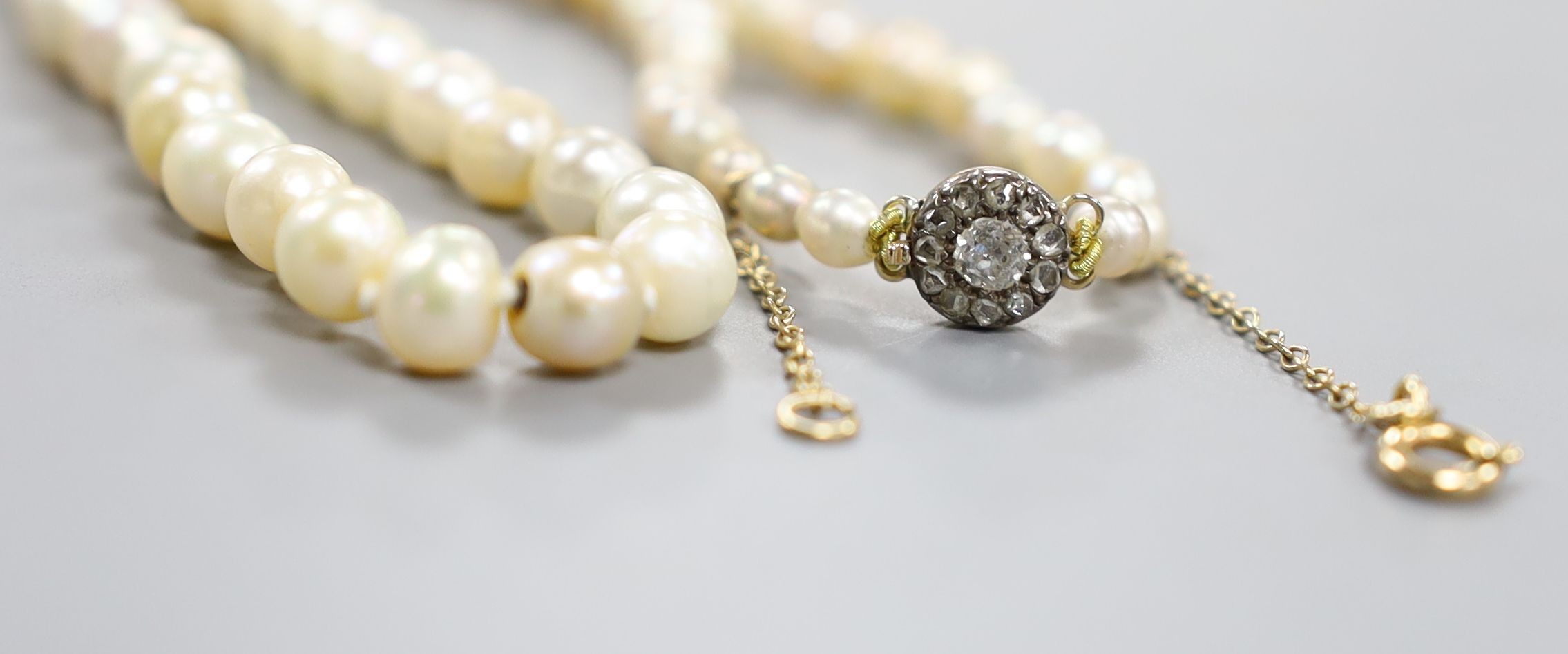 A single strand graduated cultured pearl necklace, with diamond set yellow metal clasp, 38cm.